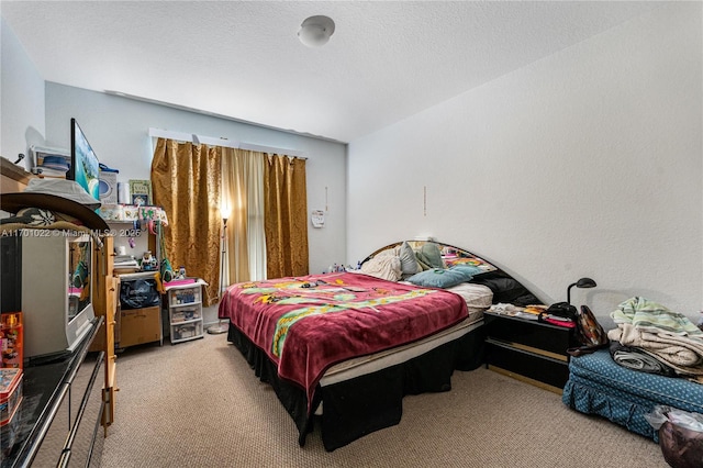 bedroom with light colored carpet and a textured ceiling