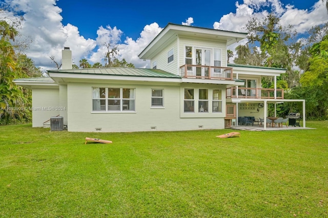 rear view of house with a patio, a balcony, central AC unit, and a lawn