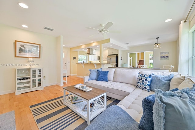 living room featuring ceiling fan and light hardwood / wood-style floors