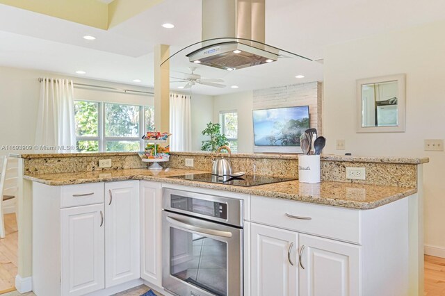 671 Live Oak Ln, La Belle, FL 33935 - kitchen with oven, light stone countertops, island range hood, and black electric cooktop