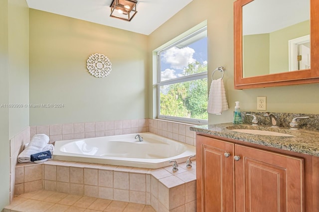 bathroom featuring tiled bath, tile patterned flooring, and vanity