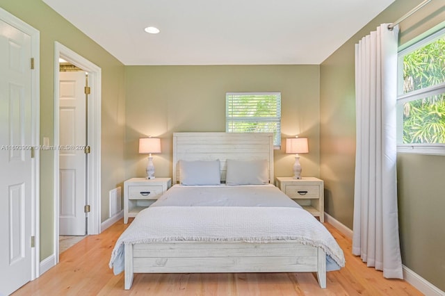 bedroom with light hardwood / wood-style flooring and multiple windows