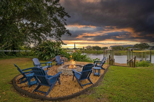671 Live Oak Ln, La Belle, FL 33935 - yard at dusk featuring a water view, a fire pit, boat lift, and a dock