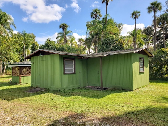 rear view of property featuring a lawn