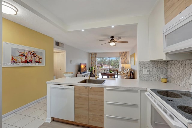 4451 NW 16th St Unit K204, Lauderhill, FL 33313 - kitchen with white appliances, a sink, a peninsula, light countertops, and tasteful backsplash