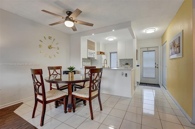 tiled dining space featuring ceiling fan