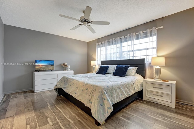 bedroom featuring ceiling fan, a textured ceiling, and hardwood / wood-style flooring