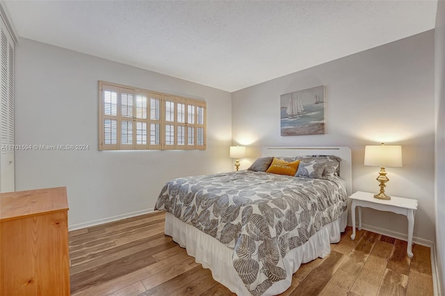 bedroom featuring a textured ceiling and hardwood / wood-style flooring