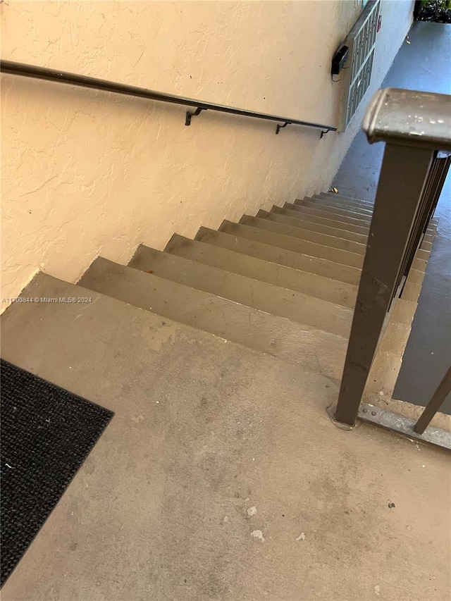 stairs with concrete flooring