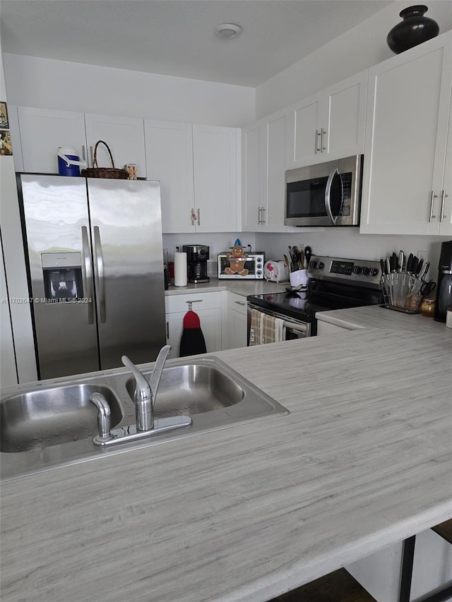 kitchen with sink, white cabinets, and appliances with stainless steel finishes