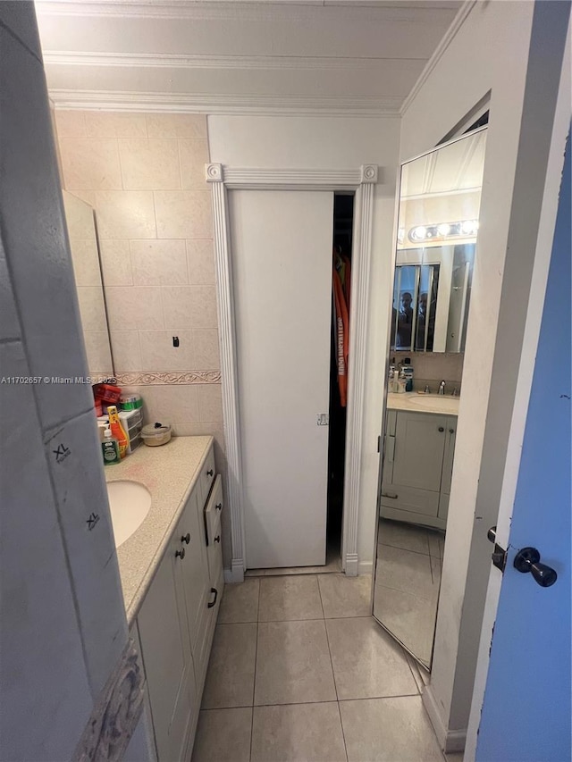 bathroom featuring vanity, tile patterned flooring, ornamental molding, and tile walls