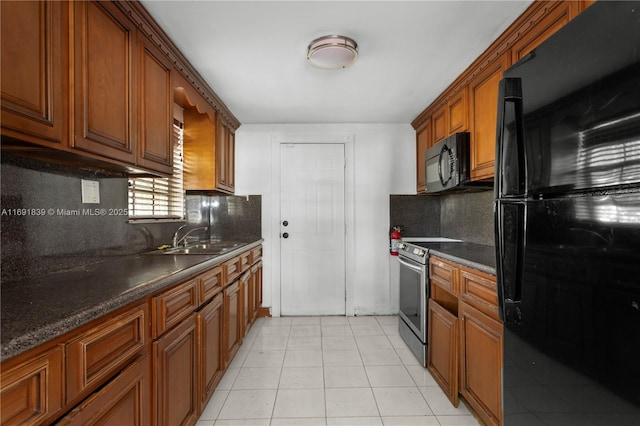 kitchen with light tile patterned floors, a sink, black appliances, dark countertops, and brown cabinets