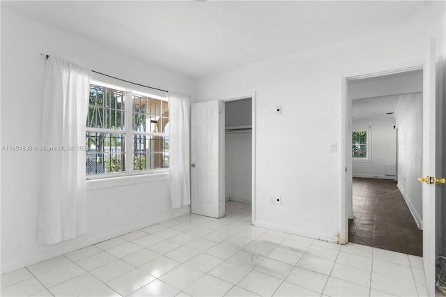 unfurnished bedroom featuring light tile patterned floors and baseboards