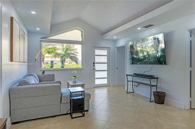 living room with lofted ceiling, a textured ceiling, and light tile patterned floors