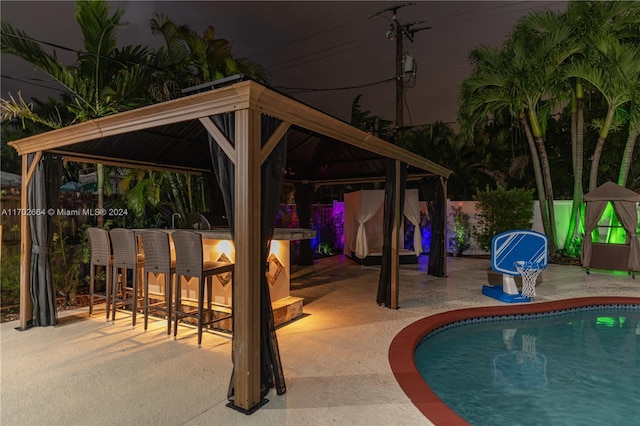 view of swimming pool featuring a gazebo, a patio area, and exterior bar