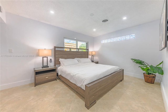 bedroom featuring light tile patterned flooring and a textured ceiling