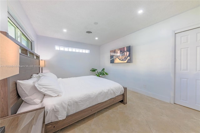 bedroom featuring light tile patterned floors and a textured ceiling