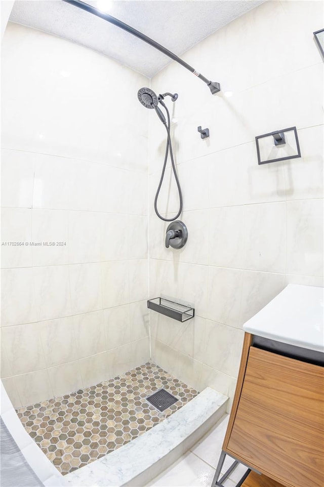 bathroom with tile patterned flooring, a tile shower, and tile walls