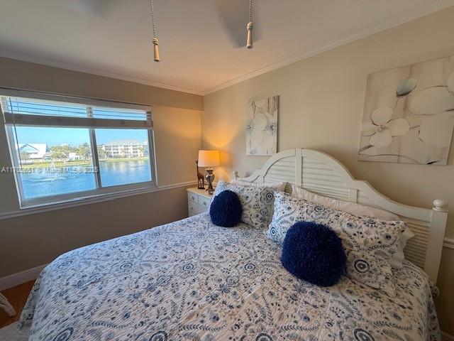 bedroom with a water view and ornamental molding