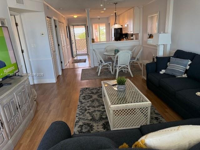 living room with crown molding and light hardwood / wood-style flooring