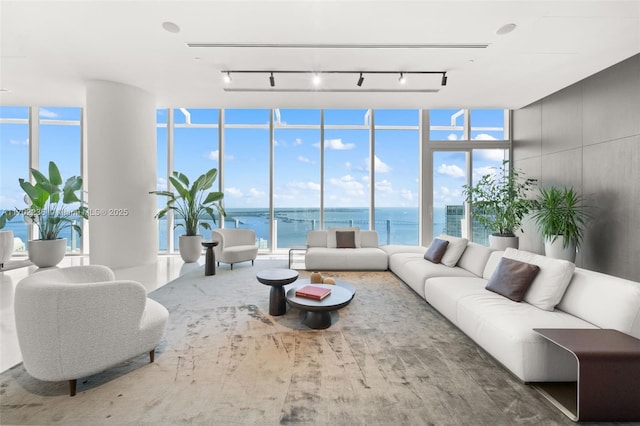 living room with floor to ceiling windows, a healthy amount of sunlight, and a water view