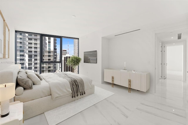 bedroom with a wall of windows, visible vents, marble finish floor, a view of city, and radiator heating unit