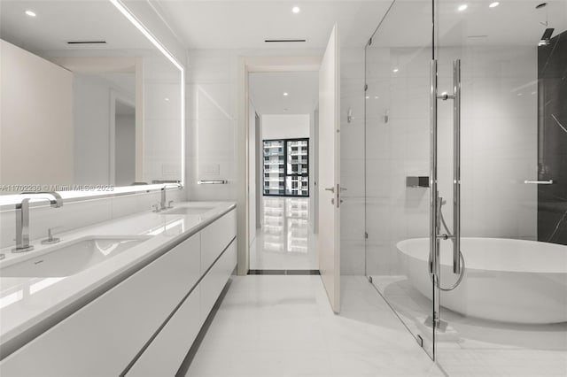 bathroom featuring double vanity, a soaking tub, a sink, and recessed lighting