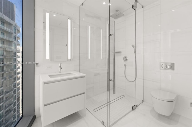 bathroom featuring toilet, a stall shower, vanity, and tile walls