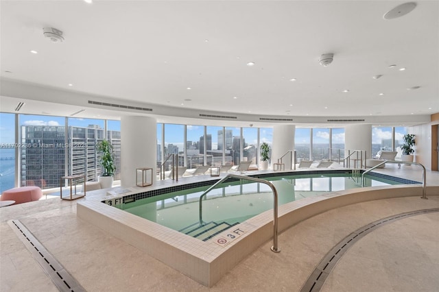 community pool featuring an indoor hot tub and a city view