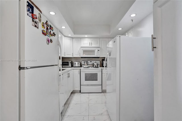 kitchen with white cabinetry and white appliances