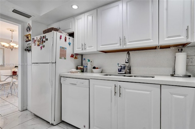 kitchen with white cabinets, white dishwasher, a chandelier, and sink