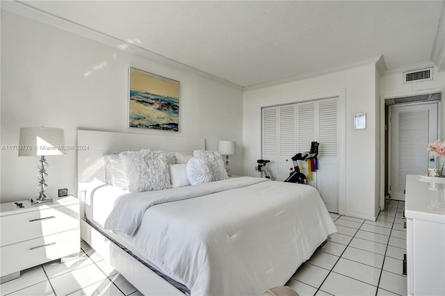 tiled bedroom with ornamental molding, a textured ceiling, and a closet