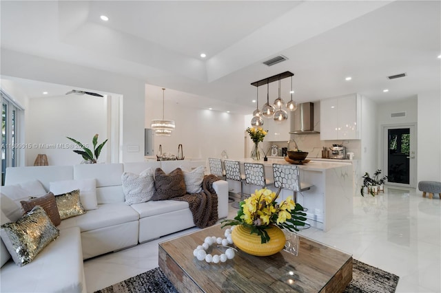 living room featuring a notable chandelier and a tray ceiling