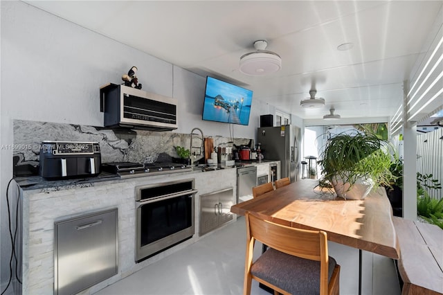 kitchen with backsplash, stainless steel appliances, and sink