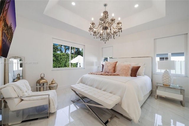 bedroom featuring a tray ceiling, a chandelier, and multiple windows