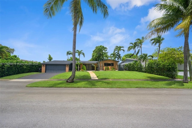 ranch-style home with a front lawn and a garage