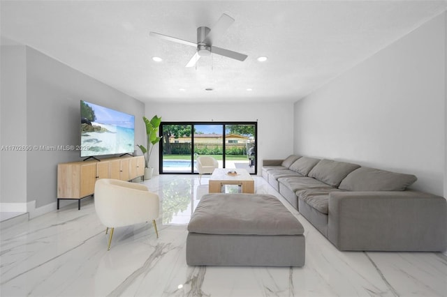 living room with ceiling fan and a textured ceiling