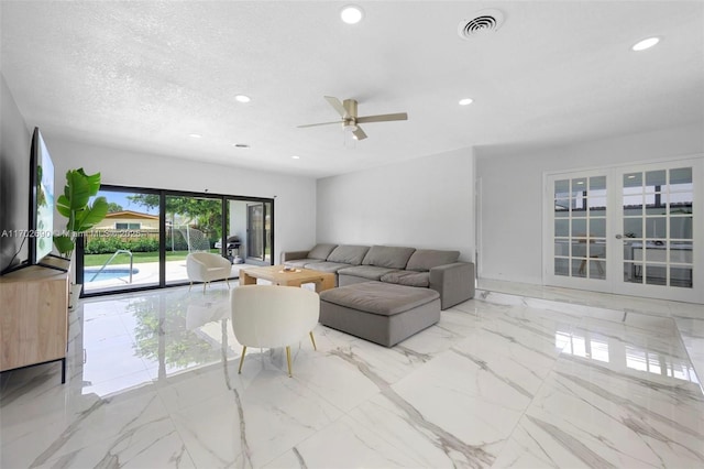 living room with ceiling fan and a textured ceiling