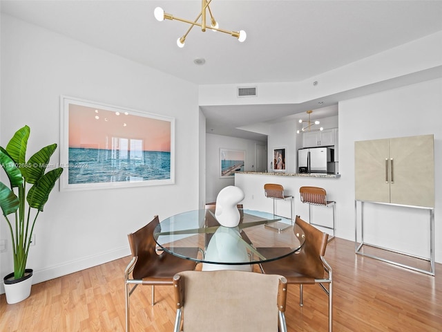 dining room featuring light hardwood / wood-style flooring and a notable chandelier