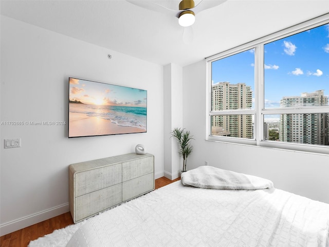 bedroom with multiple windows, wood-type flooring, and ceiling fan