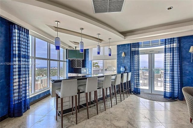 interior space featuring a wealth of natural light, french doors, and pendant lighting