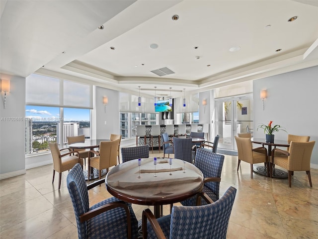 dining room with a raised ceiling and a wealth of natural light