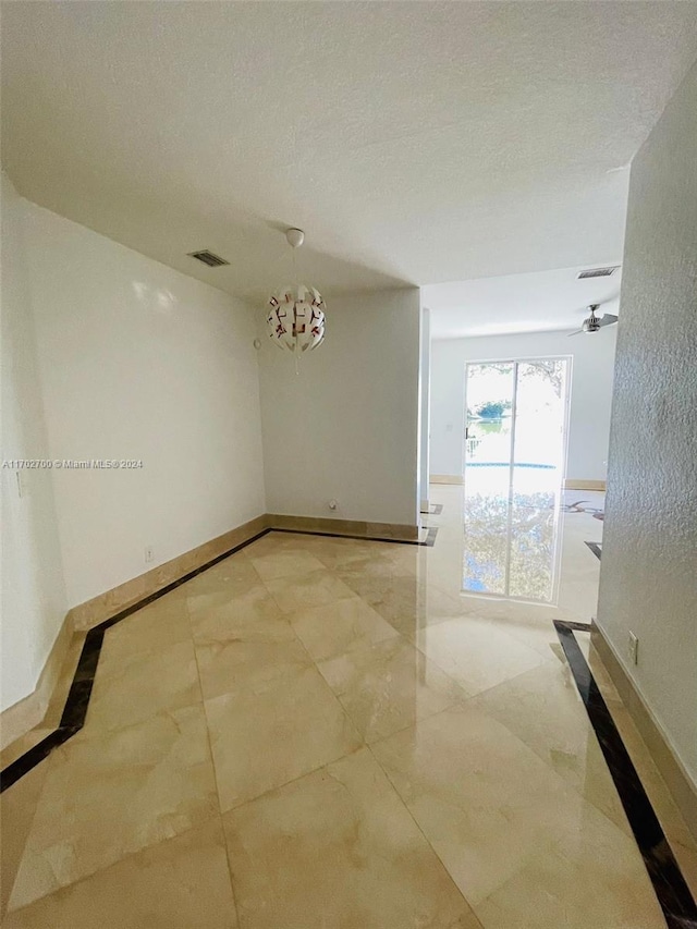 unfurnished room with a textured ceiling and ceiling fan