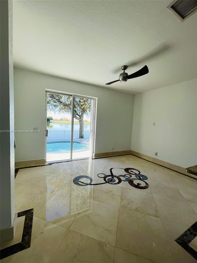 unfurnished room featuring a textured ceiling and ceiling fan