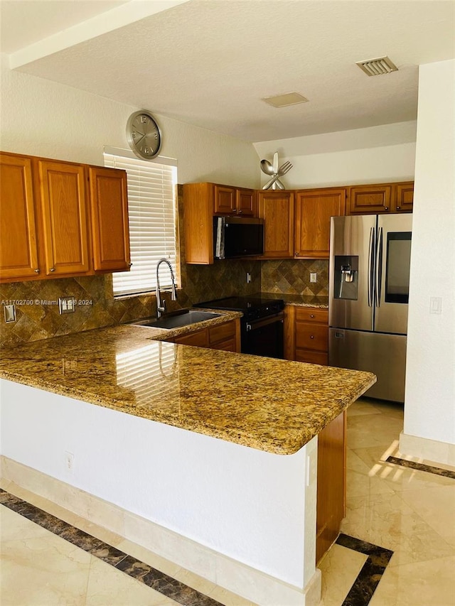 kitchen with kitchen peninsula, backsplash, stainless steel appliances, sink, and dark stone countertops