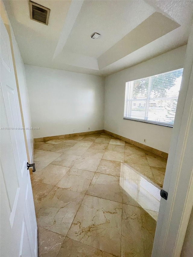 unfurnished room featuring a tray ceiling