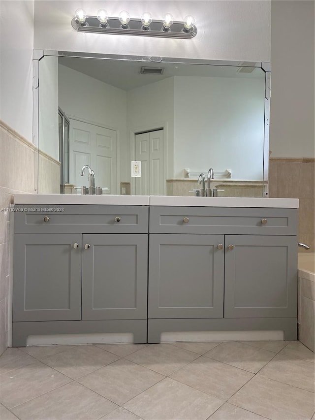 bathroom with tile patterned floors, vanity, and a bath