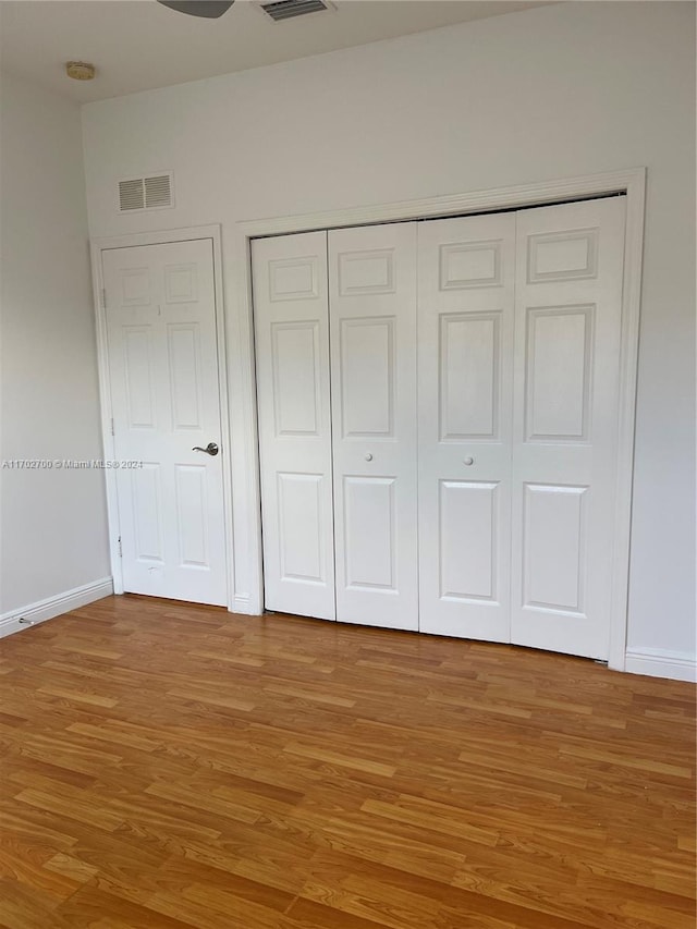 unfurnished bedroom with hardwood / wood-style floors and a closet