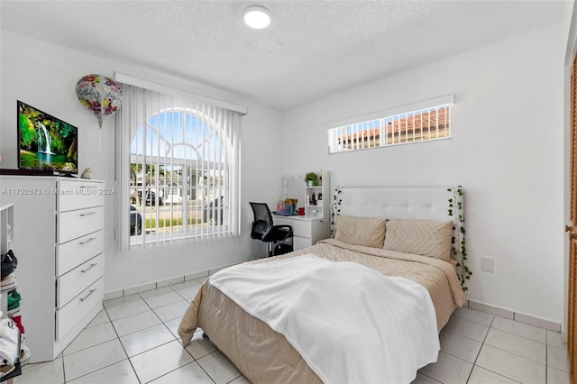 bedroom with light tile patterned flooring and a textured ceiling