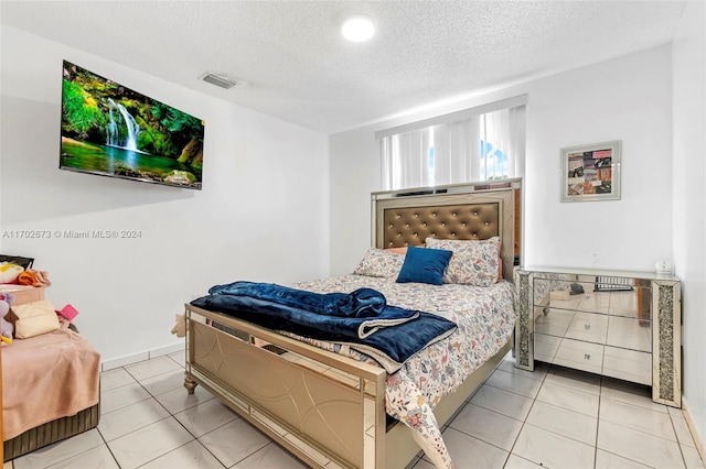 tiled bedroom featuring a textured ceiling